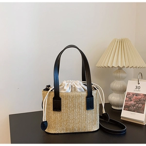 Close-up of woven straw bucket bag showing herringbone texture and canvas drawstring liner