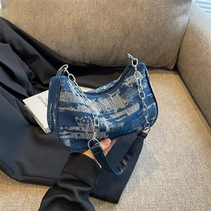 Blue denim underarm bag with abstract white patterns and a silver chain strap