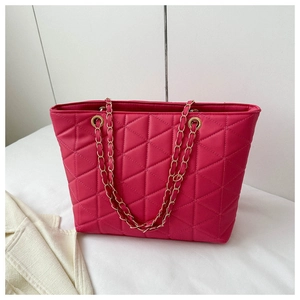 Detail of rose red large tote bag featuring quilted rhombus pattern and chain shoulder strap