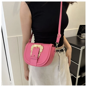 Detail of rose pink saddle bag with golden baroque buckle and adjustable leather strap