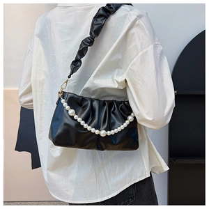 Détail du sac bandoulière plissé noir avec chaîne en perles et texture en cuir souple