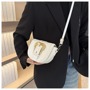 Detailed view of white saddle bag with golden Baroque style buckle on black suit jacket