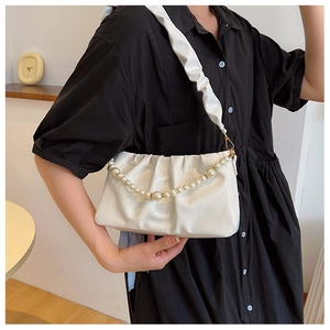 Gros plan du sac à bandoulière froncé blanc avec chaîne perlée et texture nuage