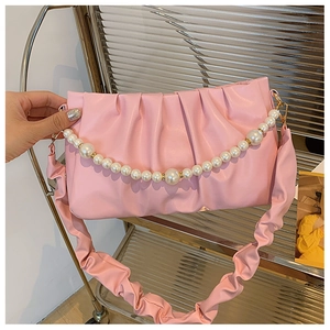 Détail du sac à main plissé rose avec chaîne de perles et anse froncée stylée