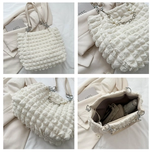 Detail of white bubble texture tote bag with elegant pearl and metal chain straps