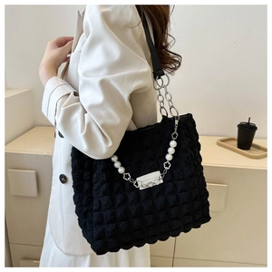 Close-up of black bubble textured tote bag featuring a decorative pearl and floral chain