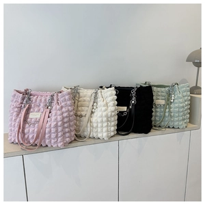 Detail of quilted texture shoulder bags with metal chain straps in multiple pastel colors