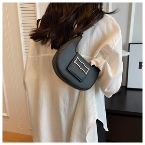 Sac à bandoulière croissant noir avec boucle en métal argenté porté par un mannequin