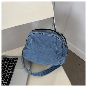 Detail view of denim crossbody bag with vintage washed texture and double zippers