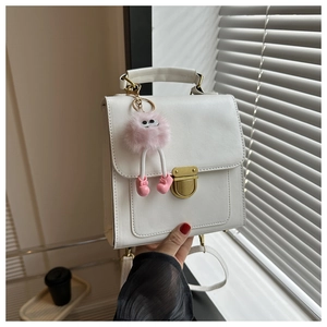 Dettaglio borsa bianca in pelle PU con fibbia dorata e ciondolo a forma di mostro rosa