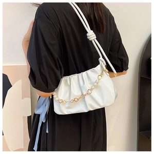Detailed back view of white ruched cloud bag with pearl chain on black dress