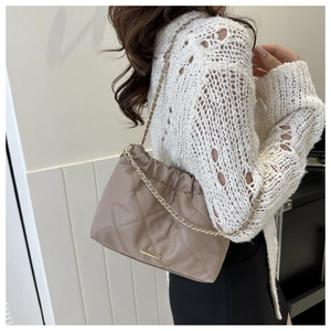 Detail of taupe quilted shoulder bag with gold chain strap and textured leather finish