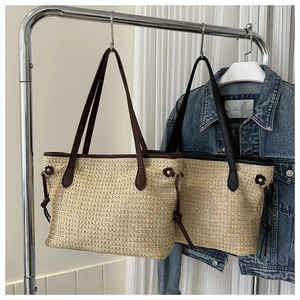 Detail of hand-woven straw tote bags with premium leather straps and V-shaped texture
