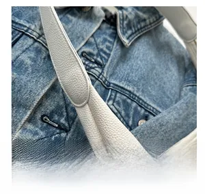 Detail of white lychee grain leather tote bag with sturdy shoulder strap stitching