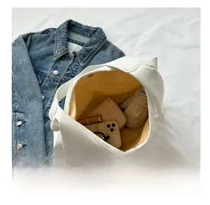 Top view of white hobo bag showing spacious interior with phone, umbrella, and wallet