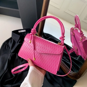 Neon pink pleated leather crossbody bag with knot handle and golden metal accents