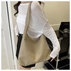 Detail of khaki hobo bag showing litchi grain texture and large capacity on shoulder