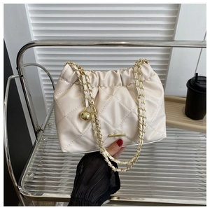 Detail of beige quilted chain bag with soft pleats and decorative gold ball charm