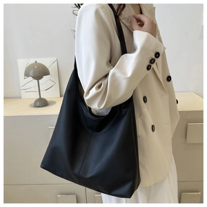 Minimalist black matte PU leather tote bag shown on model with professional office attire
