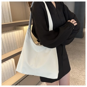 White pebbled leather large hobo bag shown on shoulder for daily commute use