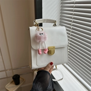 Elegante borsa a tracolla bianca con fibbia dorata e grazioso ciondolo mostro di peluche