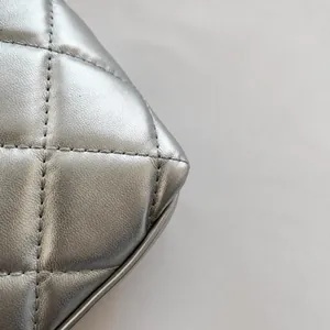 Makrodetail der silbernen gesteppten Kettentasche zeigt hochwertige metallische Lederstruktur
