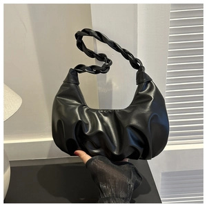 Detail of black pleated hobo bag with braided handle and cloud-like leather texture