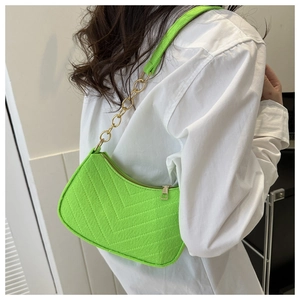 Shoulder bag in fluorescent green felt fabric with V-stitch and gold chain strap on model