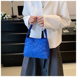 Detail van helderblauwe handtas met hartvormige stiksels en elegante handgreep van oxford