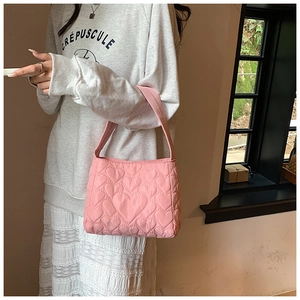 Detail van roze gewatteerde shopper met hartjespatroon en zachte nylon textuur