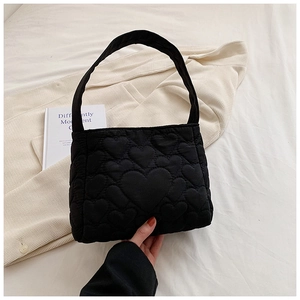Detailopname van zwarte gewatteerde shopper met gedetailleerde hartstiksels