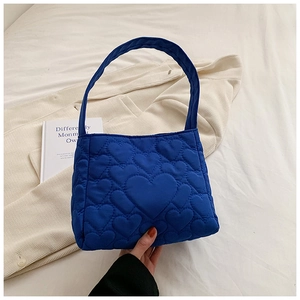 Detail van de blauwe gewatteerde draagtas met dicht 3D-hartpatroon op nylon weefsel