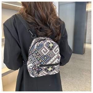 Ethnic style mini backpack featuring colorful geometric weaving and black nylon straps