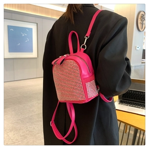 Close-up of pink rhinestone mini backpack with silver metal zippers and adjustable straps