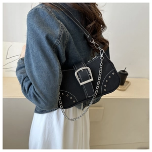 Detail of black canvas shoulder bag with silver buckle, rivets, and metal chain strap