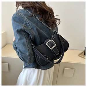 Detail view of black canvas shoulder bag with silver buckle and white contrast stitching