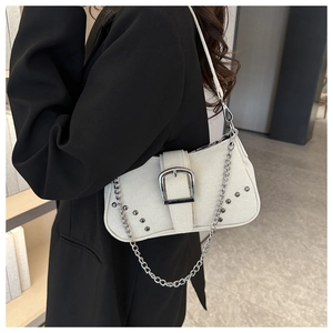 Detail of cream canvas underarm bag with silver rivets and metallic chain strap