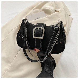 Detail of black canvas shoulder bag with white stitching and silver metal buckle