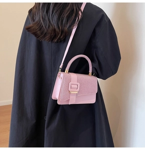 Vue latérale du sac bandoulière rose à rabat pailleté porté par un mannequin