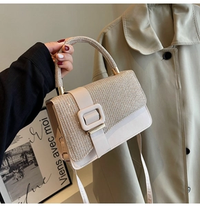 Close-up of beige crossbody bag with shimmering rhinestone texture and leather square buckle
