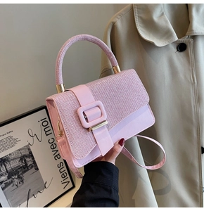 Detailed view of pink glossy stone-textured handbag with glitter top handle and gold buckles