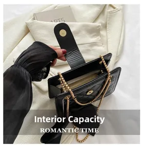 Detail view of the black quilted crossbody bag interior with a functional zipper pocket