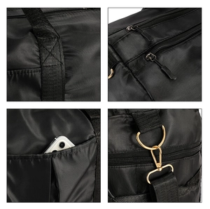 Close-up of black nylon travel bag showing gold metal hardware and reinforced stitching