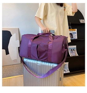 Purple travel duffel bag with back trolley sleeve shown on a silver suitcase