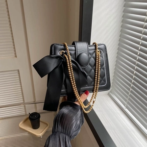 Quilted black crossbody bag with a large satin bow and golden chain strap for women