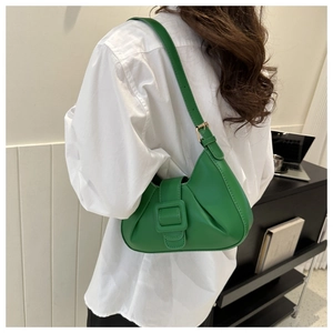 Close-up of emerald green leather hobo bag showing side pleats and adjustable strap