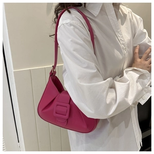 Fashionable rose red underarm bag with large square buckle and pleated details on model