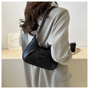 Close-up of minimalist black hobo bag with large decorative square buckle and PU leather finish
