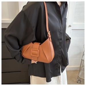 Close-up of brown crescent hobo bag with pleated texture and stylish oversized buckle detail