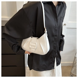 Close-up of white pleated crescent shoulder bag featuring a large square buckle and PU leather